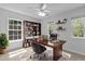 Bright home office with a large desk, built-in bookshelf, and natural light from multiple windows at 1104 Pebblestone Drive, Durham, NC 27703