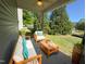 Charming covered porch with comfortable seating, a ceiling fan, and a view of the yard at 1104 Pebblestone Drive, Durham, NC 27703