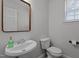 Cozy powder room with a pedestal sink, stylish mirror, and a toilet at 1104 Pebblestone Drive, Durham, NC 27703