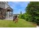 Landscaped backyard features a patio with walkout access to the grassy lawn at 112 Bellmont Crest Dr, Holly Springs, NC 27540