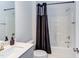 Bathroom with modern vanity and bathtub with shower; accented with a dark shower curtain at 112 Bellmont Crest Dr, Holly Springs, NC 27540