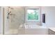 Bathroom featuring marble tile floors, a shower, a soaking tub and a window at 112 Bellmont Crest Dr, Holly Springs, NC 27540