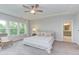 Bright bedroom with carpet, a ceiling fan, and natural light from large windows overlooking greenery at 112 Bellmont Crest Dr, Holly Springs, NC 27540