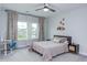 Cozy bedroom featuring a ceiling fan, neutral walls, and a window at 112 Bellmont Crest Dr, Holly Springs, NC 27540
