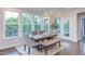 Dining room with large windows, a stylish table setting, and access to an outdoor balcony at 112 Bellmont Crest Dr, Holly Springs, NC 27540