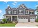 Charming two-story home features a stone facade, gray siding, and a well-manicured lawn at 112 Bellmont Crest Dr, Holly Springs, NC 27540