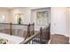 Upstairs hallway boasts dark wood floors, railing and a painting, creating an inviting space at 112 Bellmont Crest Dr, Holly Springs, NC 27540