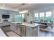 Open concept kitchen, dining, and living area featuring an island with seating and ample natural light at 112 Bellmont Crest Dr, Holly Springs, NC 27540