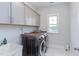 Well-equipped laundry room with washer, dryer, ample cabinetry, and marble floors at 112 Bellmont Crest Dr, Holly Springs, NC 27540