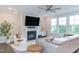Comfortable living room with a fireplace, large windows, and a plush gray sectional sofa at 112 Bellmont Crest Dr, Holly Springs, NC 27540