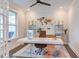 Bright home office with a modern desk, ceiling fan, and ample natural light from large windows at 112 Bellmont Crest Dr, Holly Springs, NC 27540