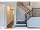 Elegant staircase with dark wood steps and black iron railing, complemented by neutral walls at 112 Bellmont Crest Dr, Holly Springs, NC 27540