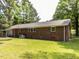 A brick house with a spacious green backyard, surrounded by mature trees at 114 Brenrose Cir, Durham, NC 27705