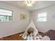 Bright bedroom featuring playful decor, teepee tent, and hardwood floors complemented by a patterned rug at 114 Brenrose Cir, Durham, NC 27705