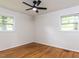 Clean, open bedroom featuring hardwood floors and natural light from two windows, offering a serene and spacious feel at 114 Brenrose Cir, Durham, NC 27705