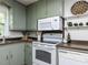 Traditional kitchen featuring olive-green cabinets, brown countertops, and white appliances for a charming, functional space at 114 Brenrose Cir, Durham, NC 27705