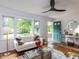 Bright living room with hardwood floors, a comfortable sofa, and large windows overlooking the yard at 114 Brenrose Cir, Durham, NC 27705