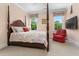 Bedroom contains a four poster bed, sitting chair, and two windows at 115 Founders Ridge Dr, Chapel Hill, NC 27517