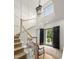 Bright foyer featuring a staircase, light hardwood floors, decorative rug, and black double doors at 115 Founders Ridge Dr, Chapel Hill, NC 27517