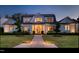 Stunning home with manicured lawn, lush landscaping and inviting entryway at dusk at 115 Founders Ridge Dr, Chapel Hill, NC 27517