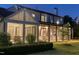 Inviting back porch with white rocking chairs at dusk, surrounded by lush greenery and manicured lawn at 115 Founders Ridge Dr, Chapel Hill, NC 27517