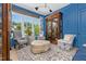 Bright sitting room features custom blue millwork and trim, designer furniture and hardwood floors at 115 Founders Ridge Dr, Chapel Hill, NC 27517