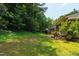 View of spacious backyard with lush greenery at 115 Heatherwood Dr, Apex, NC 27502