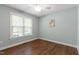Bedroom with hardwood floors, a ceiling fan, and window overlooking greenery at 115 Heatherwood Dr, Apex, NC 27502