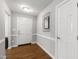 Clean and well-lit foyer with hardwood floors, a decorative mirror, and a white front door at 115 Heatherwood Dr, Apex, NC 27502