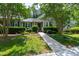 Charming home features a well-manicured front yard with lush greenery and a welcoming walkway to the front door at 115 Heatherwood Dr, Apex, NC 27502