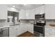 Modern kitchen featuring stainless steel appliances, granite countertops, and ample cabinet space at 115 Heatherwood Dr, Apex, NC 27502