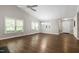 Large living room with big windows, hardwood floors, and a ceiling fan at 115 Heatherwood Dr, Apex, NC 27502