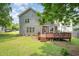 A spacious backyard showcasing a large wooden deck, a well-maintained lawn, and the rear exterior of the home at 1230 Golden Bluff Ln, Fuquay Varina, NC 27526