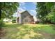 Expansive backyard featuring a well-kept lawn, mature trees, and a glimpse of the home's back deck at 1230 Golden Bluff Ln, Fuquay Varina, NC 27526