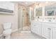 Bright bathroom featuring double sinks, a glass enclosed shower, and white cabinets at 1230 Golden Bluff Ln, Fuquay Varina, NC 27526