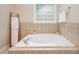 A bathtub with decorative tilework and a unique window and ladder-style towel rack at 1230 Golden Bluff Ln, Fuquay Varina, NC 27526