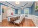 Elegant dining room with blue walls, wainscoting, hardwood floors and a large table set for dinner at 1230 Golden Bluff Ln, Fuquay Varina, NC 27526