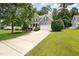 A two-story home boasting a well-maintained lawn, mature trees, and a paved driveway leading to a two-car garage at 1230 Golden Bluff Ln, Fuquay Varina, NC 27526