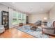 Spacious living room with hardwood floors, a ceiling fan, and large windows overlooking the backyard at 1230 Golden Bluff Ln, Fuquay Varina, NC 27526
