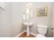 A cozy powder room features pedestal sink, wood floors, and decor at 1230 Golden Bluff Ln, Fuquay Varina, NC 27526