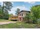 Home's exterior backyard featuring a wooden deck and small patio, complemented by a fenced yard and landscaping at 1308 Swallow Dr, Raleigh, NC 27606