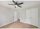 Bright bedroom featuring wood-look floors, white doors, and a lighted ceiling fan at 1308 Swallow Dr, Raleigh, NC 27606
