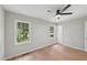 Well-lit bedroom with wood-look flooring, light walls, a ceiling fan, and dual windows at 1308 Swallow Dr, Raleigh, NC 27606