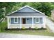 Blue home with a covered front porch, white pillars, and well-kept landscaping at 1318 N Alston Ave, Durham, NC 27701