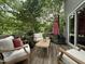 Relaxing outdoor deck space with comfortable seating, a wooden table, and shade from mature trees at 148 Langston Ridge Dr Dr, Angier, NC 27501