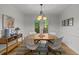 Light and airy dining room with modern light fixture, neutral colors, wood floors, and backyard views at 15 Gray Fox Ct, Durham, NC 27713
