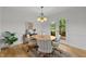 Dining room features a neutral color palette, modern chandelier, and wood floors overlooking backyard patio at 15 Gray Fox Ct, Durham, NC 27713