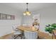 Bright dining room with neutral paint, modern light fixture, wood floors and open entryway to living room at 15 Gray Fox Ct, Durham, NC 27713