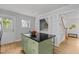 Eat-in kitchen features a green island with black countertop, wood floors, and open entry to utility area and stairs at 15 Gray Fox Ct, Durham, NC 27713
