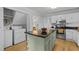 Spacious eat-in kitchen features a kitchen island with granite countertop and view of appliances and utility area at 15 Gray Fox Ct, Durham, NC 27713